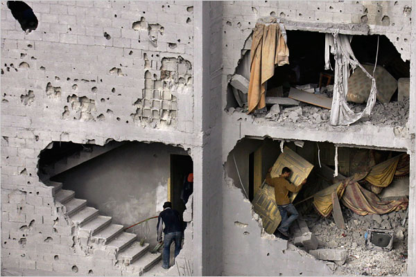 On the seventh day of Israels massive attack on Hamas sites throughout Gaza in retaliation for the recent rocket fire from the area, Palestinians collect belongings from the destroyed home of killed Hamas leader Nizar Rayyan, January 2, 2009.