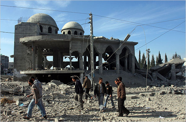 On the tenth day of Israels war against Gaza, Palestinians walk past a destroyed mosque, Beit Hanoun, January 5, 2009.