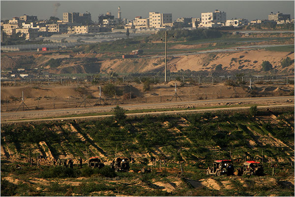 On the eleventh day of Israels war against Gaza, Israeli military vehicles idle along the border fence with Gaza, January 6, 2009.