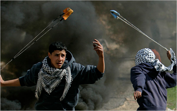 On the thirteenth day of Israels war against Gaza, Palestinian demonstrators use sling-shots to hurl stones at Israeli soldiers during a demonstration against Israel's military operation in Gaza, in the West Bank village of Bilin, near Ramallah, January 8, 2009.