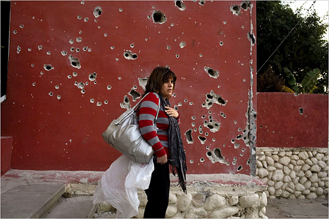 On the sixteenth day of Israels war against Gaza, an Israeli woman stands near a wall pockmarked by shrapnel from a Palestinian rocket, Beer Sheva, Israel, January 11, 2009.