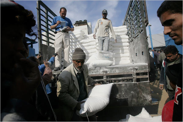 On the eighteenth day of Israels war against Gaza, Palestinians unload food aid from the United Nations Relief and Works Agency, al-Shati refugee camp, Gaza City, January 13, 2009.