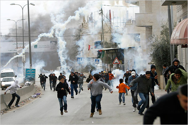 On the tweny-first day of Israels war against Gaza, Palestinian protesters near the West Bank city of Ramallah run from tear gas fired by Israeli border police, January 16, 2009.