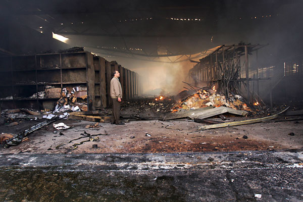 On the twenty-first day of Israels war against Gaza, a man inspects the damage at a food storage warehouse hit a day before in the Gaza headquarters of the United Nations Relief and Works Agency, January 16, 2009.