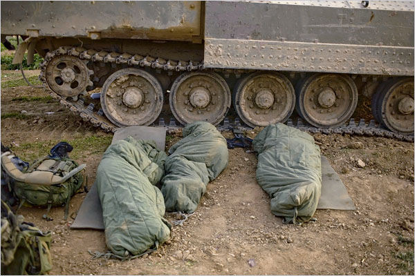 On the twenty-second day of Israels war against Gaza, Israeli soldiers sleep next to their vehicle at a staging area on the Israeli side of the border with Gaza, January 17, 2009.