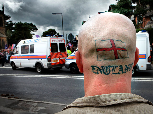 A man watches protesters demonstrating against the BNPs annual Red, White and Blue festival, near Codnor village, Derbyshire, England, August 15, 2009.