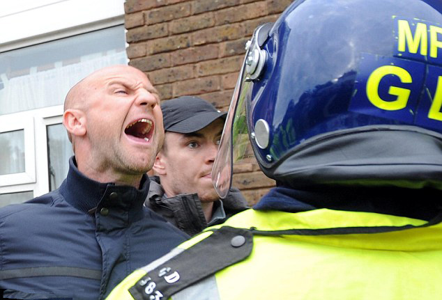 Angry right-wing protesters are held back by the police at rally outside Harrow mosque, London, September 11, 2009.