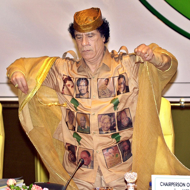 Libyan leader Muammar Al-Qaddafi adjusts his traditional clothes which are decorated with pictures of Africa's figures during the opening session of the second extraordinary summit of the Assembly of the African Union, Sirte, Libya, February 28, 2004.