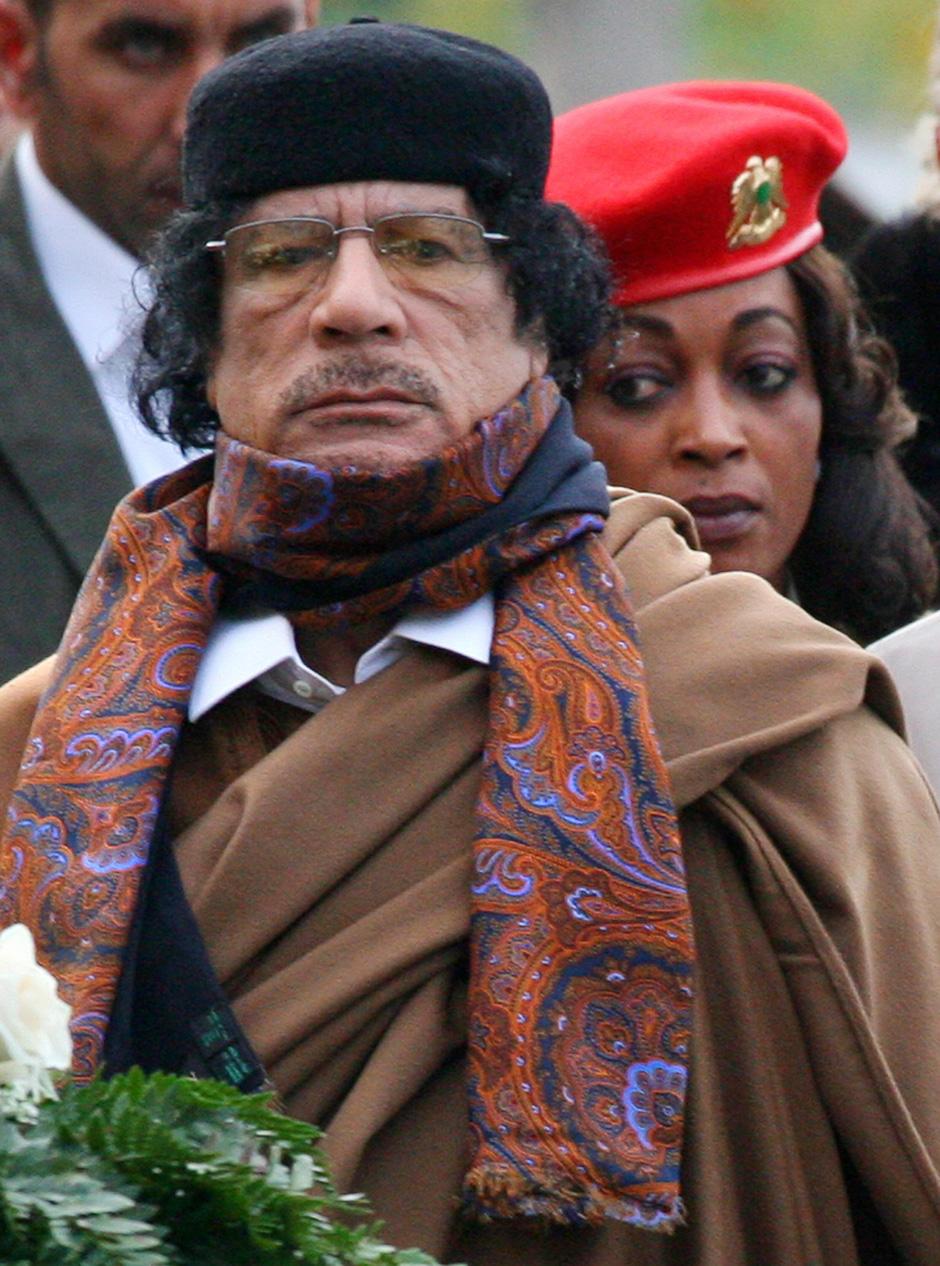 Libyan leader Muammar Al-Qaddafi, escorted by one of his female bodyguards, lays a wreath at the Tomb of the Unknown Soldier in Moscow, November 1, 2008.
