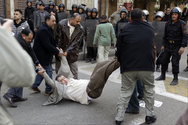 Police drag the Islamist journalist Muhammad Abdul-Qudous, a member of Press Syndicate Council, during riots led by the Muslim Brotherhood underworld gang, downtown Cairo, Egypt, January 26, 2011.