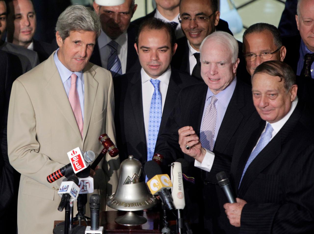 U.S Senators, John Kerry, D-Massachusetts, left, and John McCain, R-Arizona, third left, ring the bell to open Cairo Stock Exchange, as Mohammed Abd A-Salam, its Chairman, right, looks in, Cairo, June 26, 2011.