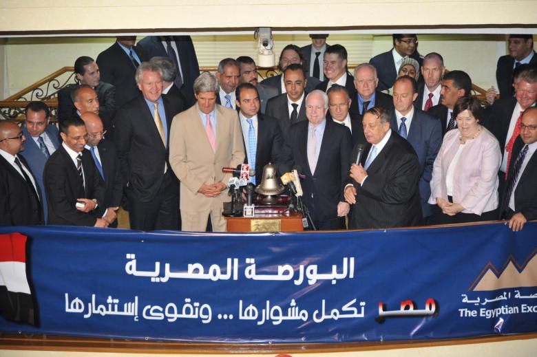 U.S Senators, John Kerry, D-Massachusetts, left, and John McCain, R-Arizona, third left, ring the bell to open Cairo Stock Exchange, as Mohammed Abd A-Salam, its Chairman, with microphone, and Margaret Scobey, the U.S. Ambassador to Egypt, right, look in, Cairo, June 26, 2011.