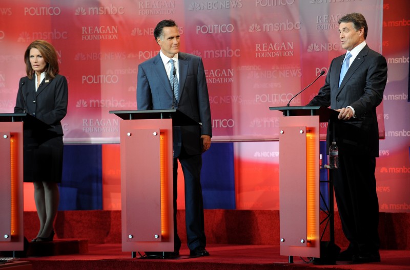 Grand Old Party (GOP) presidential candidates Michelle Bachmann (L) and Mitt Romney (C) listen as Rick Perry (R) speaks during the Reagan Centennial GOP Presidential Candidates Debate at the Reagan Librarys Air Force One Pavilion in Simi Valley, California, September 7, 2011.