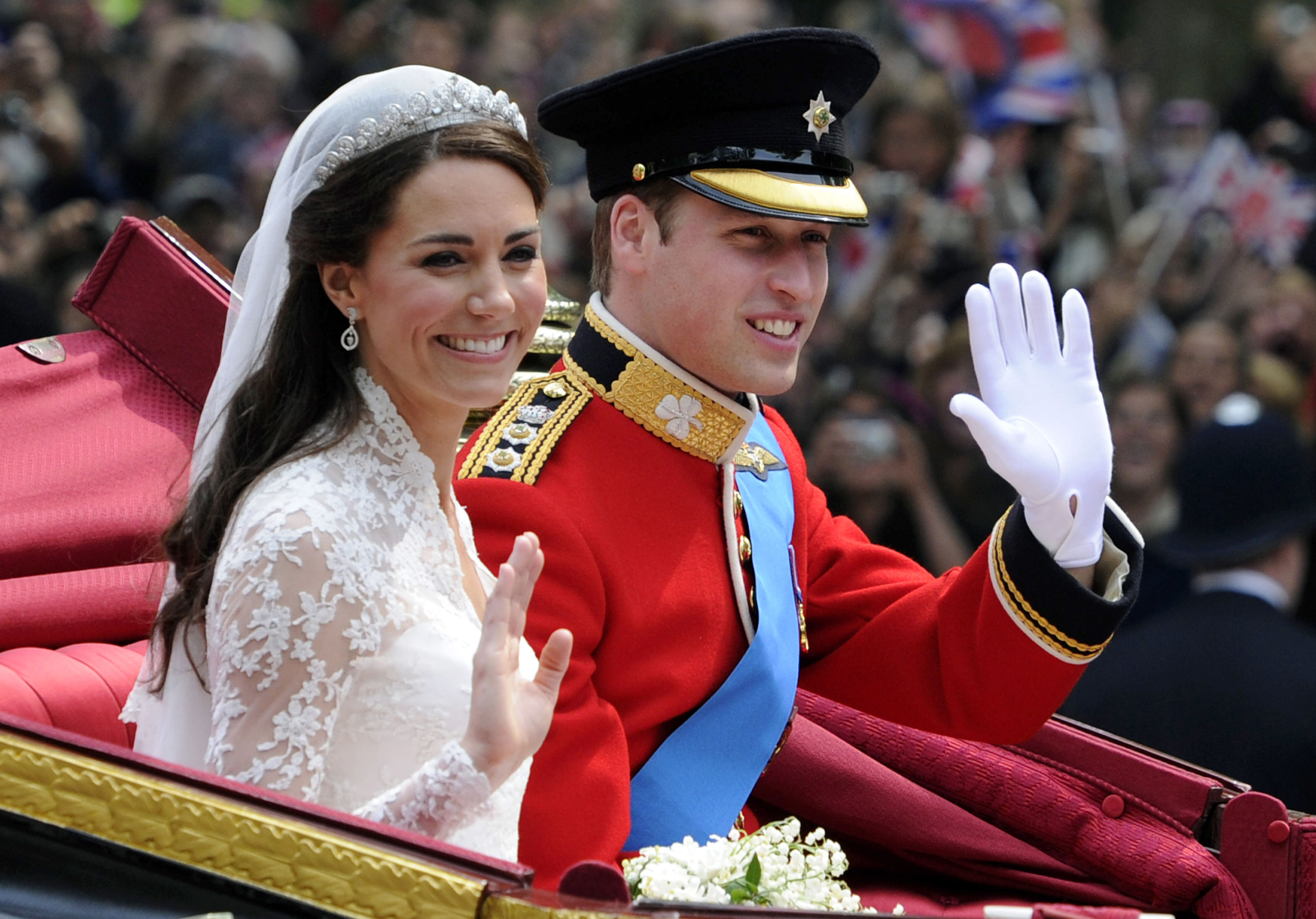 Britain's Prince William and his wife Catherine, Duchess of Cambridge, wave as they leave Westminster Abbey to Buckingham Palace in the 1902 State Landau, along the Procession Route, after their wedding in Westminster Abbey, Central London, April 29, 2011.