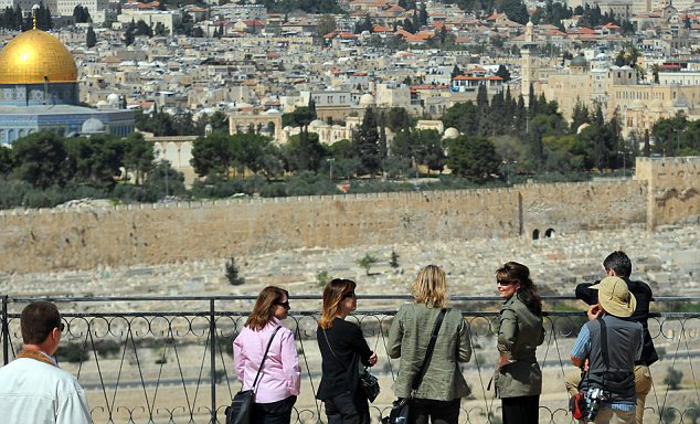 The former Alaska Governor Sarah Palin and husband Todd, fifth and seventh from left, take in the scene from the Mount of Olives in East Jerusalem as they lookout over the walled Old City, Jerusalem, March 20, 2011.